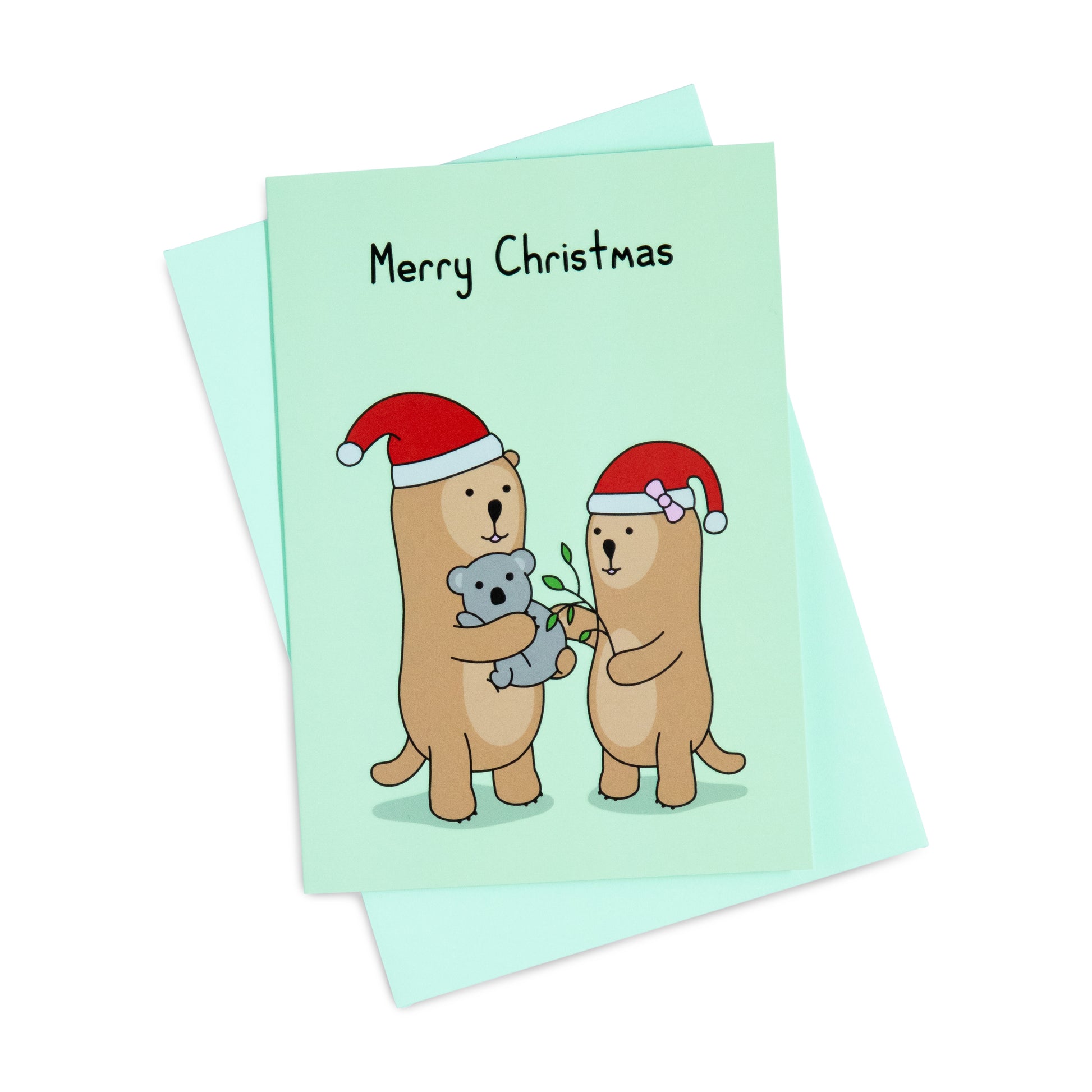 A green Christmas greeting card with a cheerful illustration of two otters in Santa hats, one is holding a koala, the other is feeding the koala leaves. The text on the card reads 'Merry Christmas'.