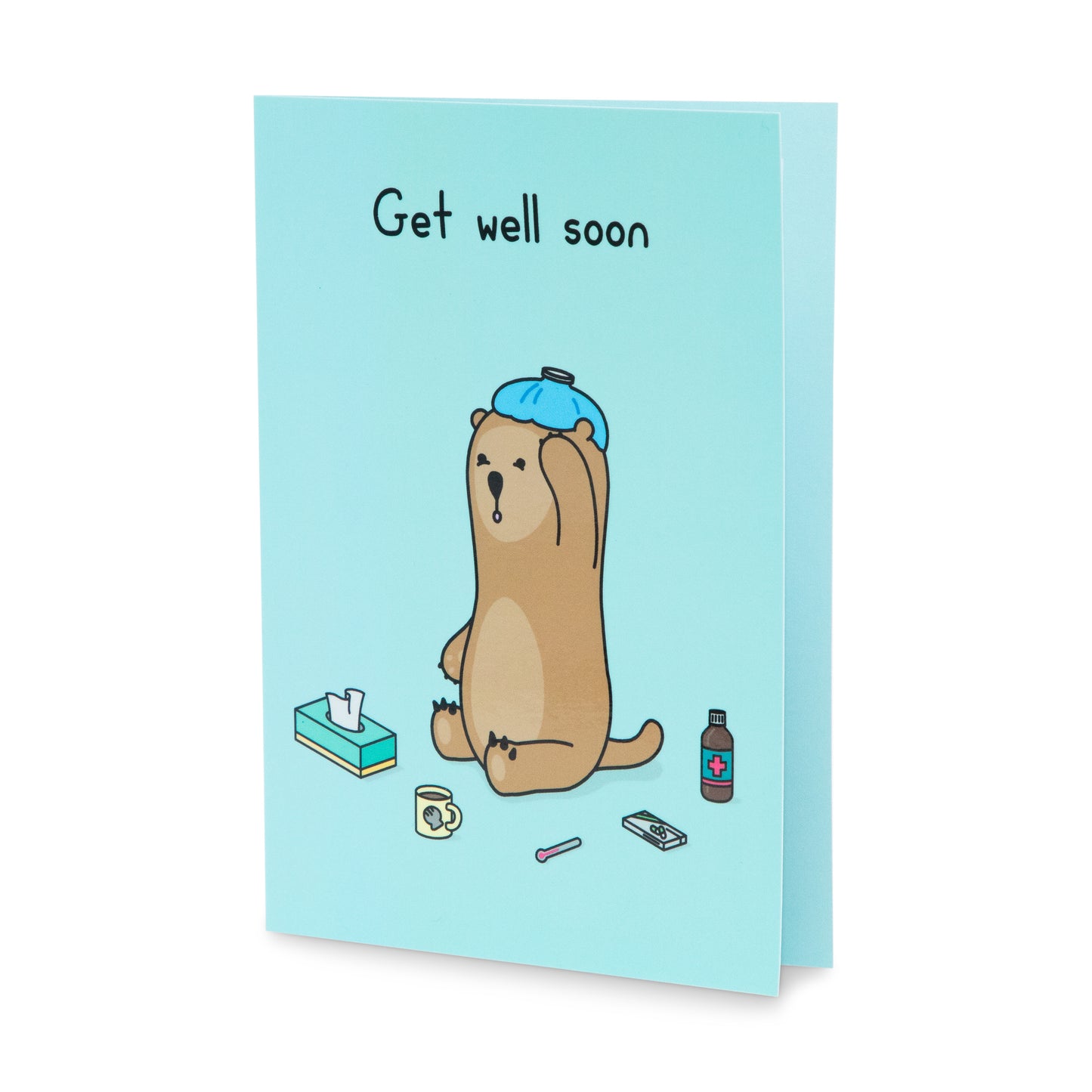 A blue get well soon greeting card with an image of an otter sitting on the ground with an icebag on his head. He is surrounded by various items, a tissue box, thermometer, a box of pills and a bottle of medicine. The text on the card reads 'Get well soon'.