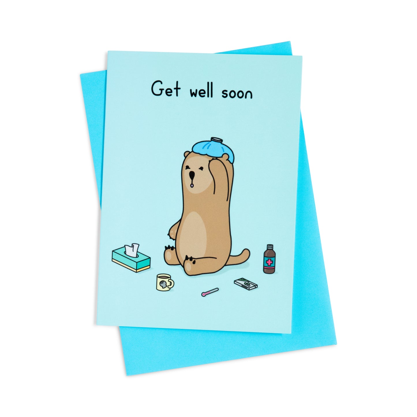 A blue get well soon greeting card with an image of an otter sitting on the ground with an icebag on his head. He is surrounded by various items, a tissue box, thermometer, a box of pills and a bottle of medicine. The text on the card reads 'Get well soon'.